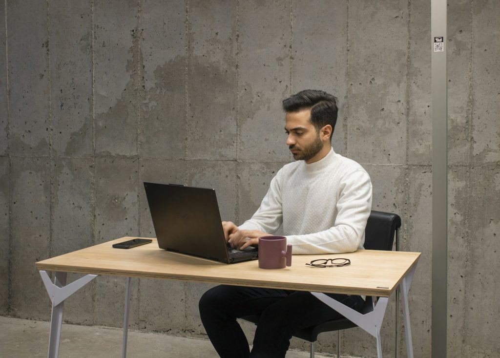 Ein Mann arbeitet konzentriert an einem Laptop am Schreibtisch