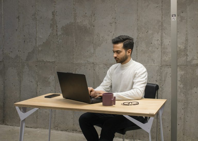 Ein Mann arbeitet konzentriert an einem Laptop am Schreibtisch